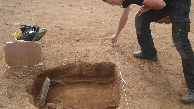 A pit lined with flat stones set up on edge 